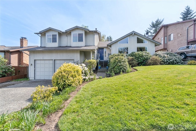 tri-level home featuring a garage, a front lawn, fence, and driveway