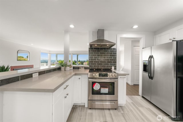 13445 SE 43rd St, Bellevue, WA 98006 - kitchen featuring decorative backsplash, appliances with stainless steel finishes, white cabinetry, recessed lighting, and wall chimney exhaust hood