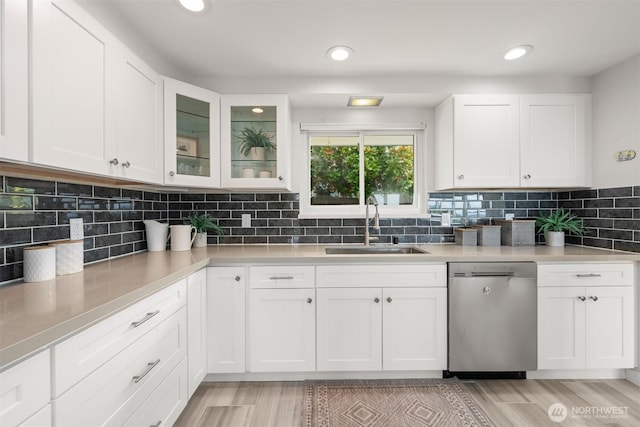 13445 SE 43rd St, Bellevue, WA 98006 - kitchen with light wood-type flooring, dishwasher, a sink, light countertops, and white cabinetry