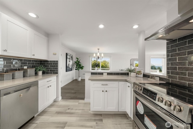 13445 SE 43rd St, Bellevue, WA 98006 - kitchen with wall chimney range hood, white cabinetry, appliances with stainless steel finishes, and tasteful backsplash