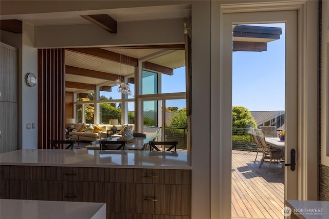 doorway to outside featuring beam ceiling