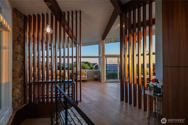 interior space with beamed ceiling, hardwood / wood-style floors, and an upstairs landing
