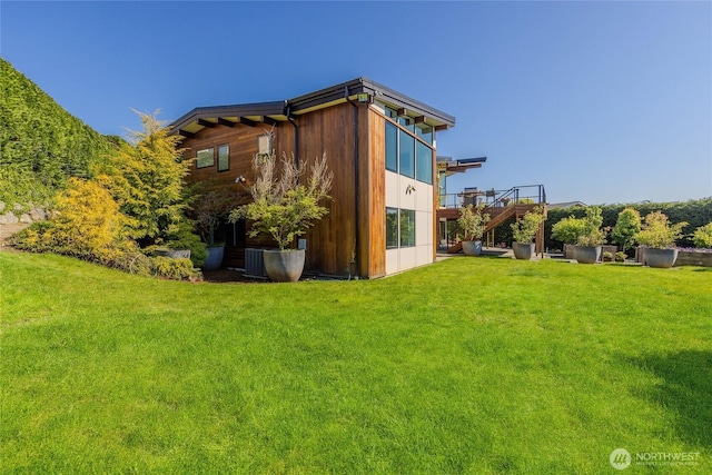 view of side of home featuring stairway, a wooden deck, and a yard