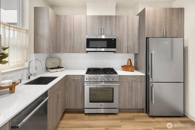 2612A SW Nevada St, Seattle, WA 98126 - kitchen featuring appliances with stainless steel finishes, a sink, modern cabinets, and light countertops