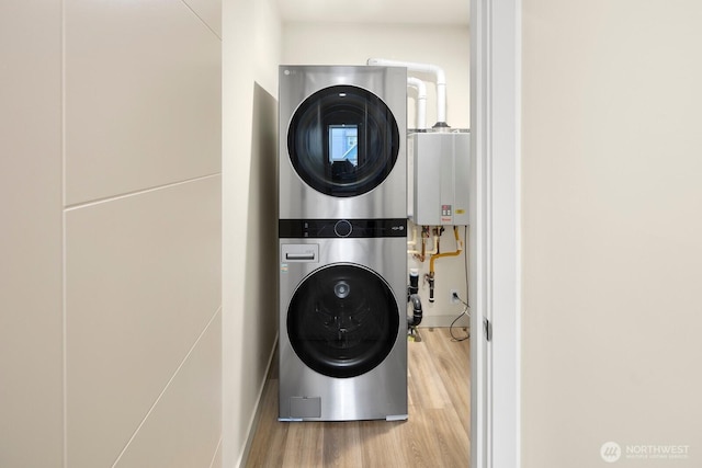2612A SW Nevada St, Seattle, WA 98126 - clothes washing area featuring stacked washer and clothes dryer, wood finished floors, and tankless water heater