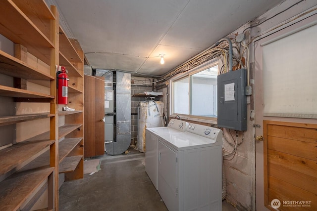 basement featuring electric panel and washing machine and clothes dryer