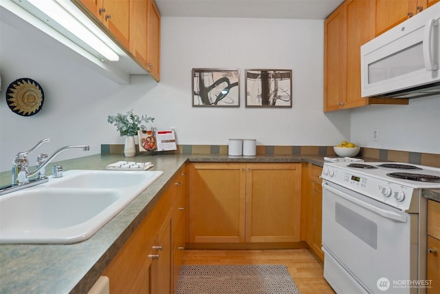 275 W Roy St Unit 216, Seattle, WA 98119 - kitchen with a sink, light wood finished floors, brown cabinets, and white appliances