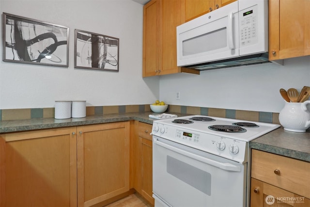 275 W Roy St Unit 216, Seattle, WA 98119 - kitchen with white appliances, brown cabinets, and dark countertops
