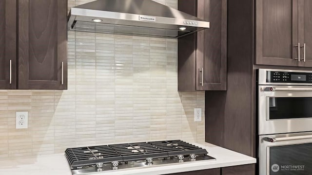 kitchen with light countertops, appliances with stainless steel finishes, ventilation hood, and backsplash