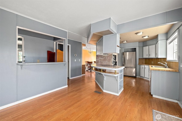 1402 22nd St NE Unit 65, Auburn, WA 98002 - kitchen featuring freestanding refrigerator, a sink, backsplash, wood finished floors, and open shelves