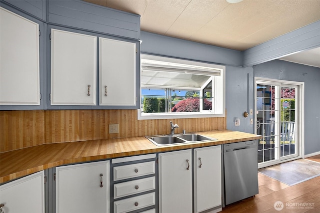 1402 22nd St NE Unit 65, Auburn, WA 98002 - kitchen with stainless steel dishwasher, a sink, butcher block counters, wood finished floors, and white cabinets