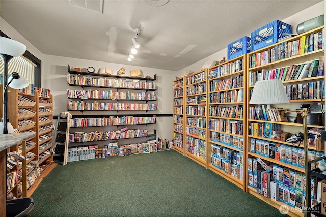 1402 22nd St NE Unit 65, Auburn, WA 98002 - miscellaneous room with wall of books, carpet flooring, a ceiling fan, rail lighting, and a textured ceiling