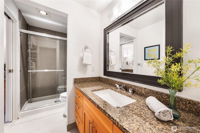 full bath featuring vanity, tile patterned floors, a stall shower, and toilet