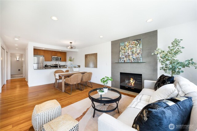 living area featuring light wood-type flooring, recessed lighting, and a fireplace