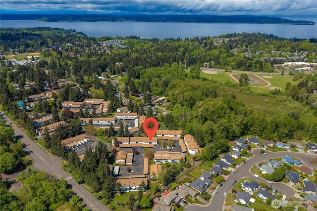 bird's eye view with a water view, a residential view, and a wooded view