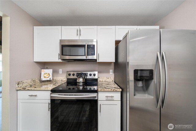kitchen with appliances with stainless steel finishes, white cabinets, and light stone countertops