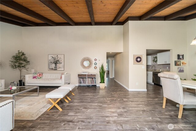 living area featuring a high ceiling, beam ceiling, baseboards, wooden ceiling, and wood finished floors