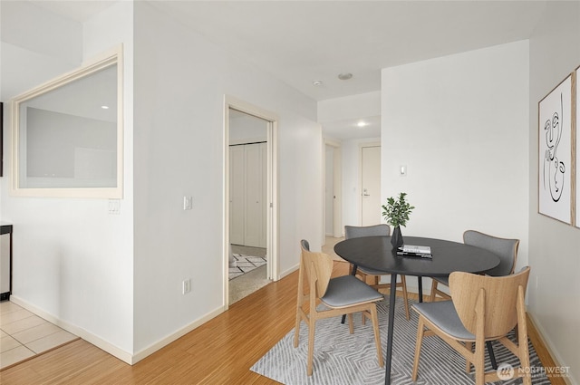 dining room featuring baseboards, recessed lighting, and light wood-style flooring