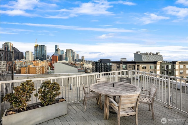 wooden deck featuring a view of city and outdoor dining area