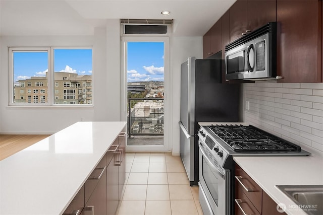 kitchen with light countertops, dark brown cabinetry, tasteful backsplash, and stainless steel appliances