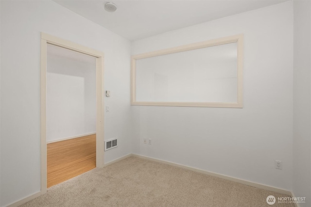 spare room with visible vents, carpet, and baseboards