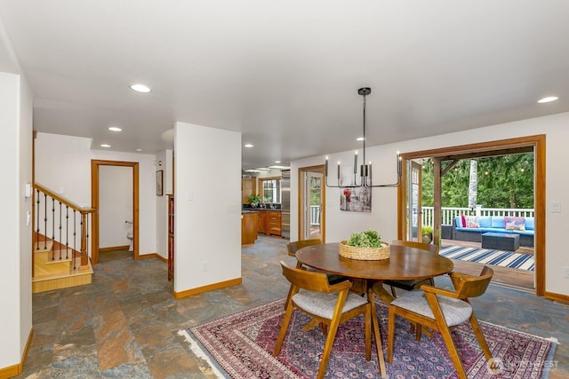 dining room with an inviting chandelier, stone finish floor, baseboards, and stairway
