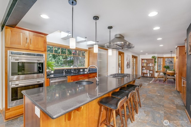 kitchen with recessed lighting, a sink, stone finish floor, and stainless steel appliances