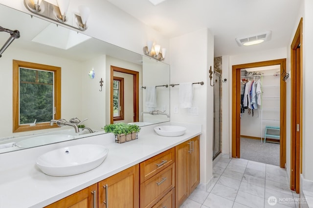 bathroom with a sink, a shower stall, marble finish floor, and visible vents