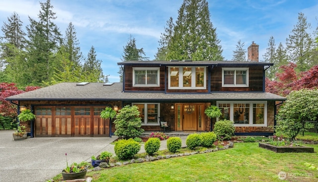 prairie-style house with an attached garage, a front lawn, a porch, a chimney, and driveway