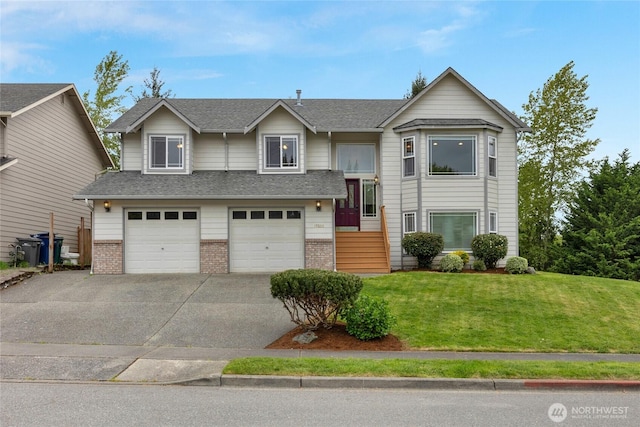 raised ranch with concrete driveway, brick siding, an attached garage, and a front lawn