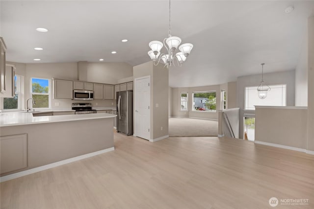 kitchen with light countertops, stainless steel appliances, open floor plan, and a wealth of natural light