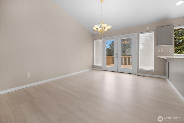 unfurnished dining area featuring lofted ceiling, baseboards, a chandelier, french doors, and light wood-style flooring