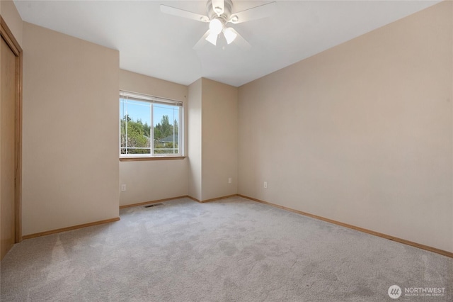 unfurnished room with baseboards, a ceiling fan, carpet flooring, and visible vents