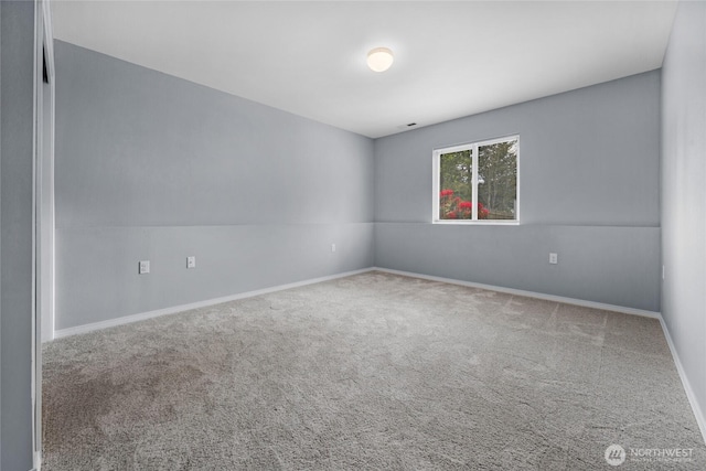 unfurnished room with carpet floors and baseboards