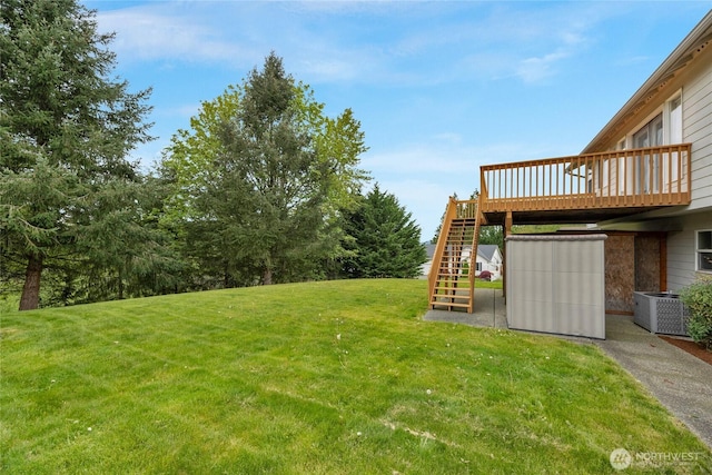 view of yard featuring a wooden deck, central air condition unit, and stairway