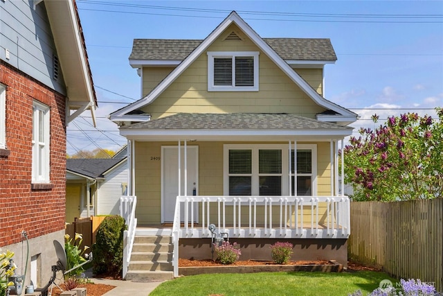 view of front of house with a porch, a shingled roof, and fence