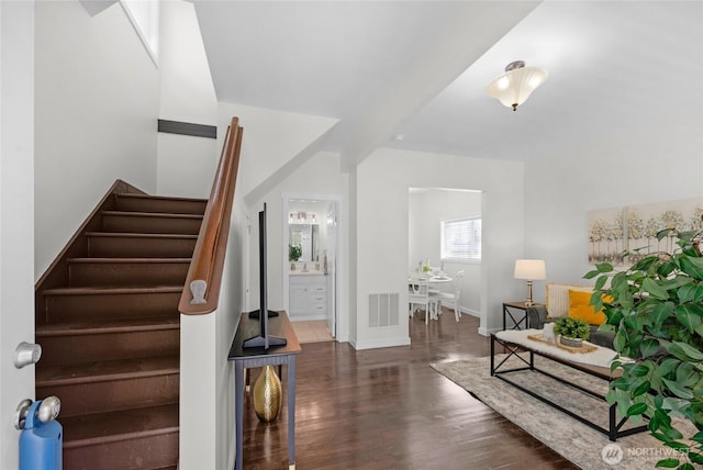 interior space featuring visible vents, baseboards, wood finished floors, and stairway