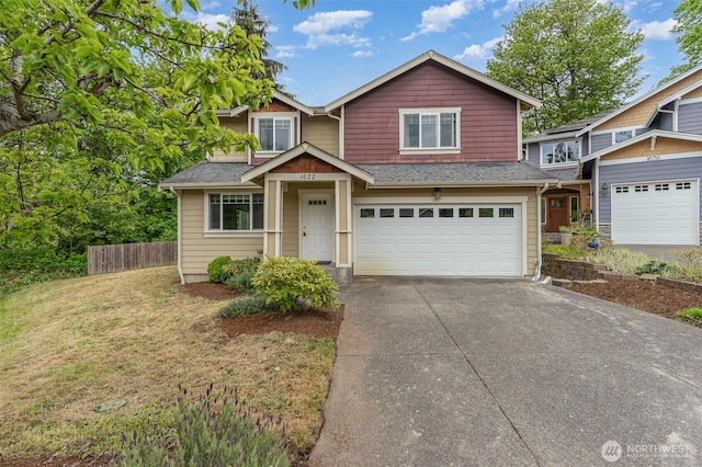 craftsman-style home featuring fence, driveway, a front yard, and a garage