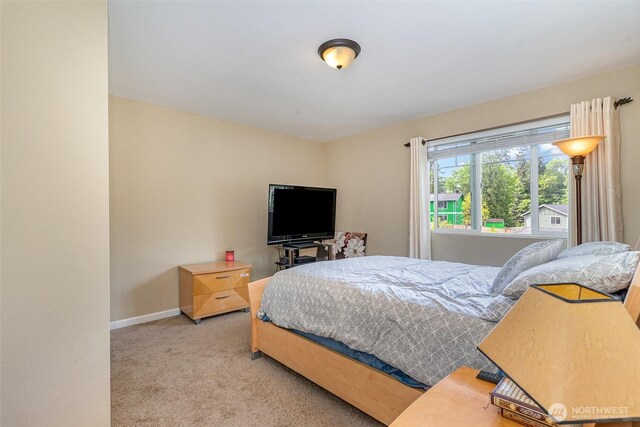 bedroom with baseboards and light carpet
