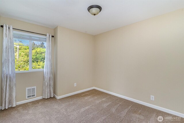 unfurnished room featuring baseboards, visible vents, and carpet