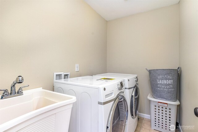 laundry room with laundry area, washer and dryer, baseboards, a sink, and light tile patterned floors