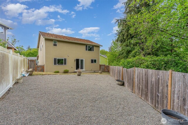 rear view of house featuring a fenced backyard