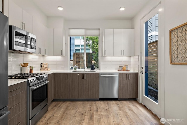 2414 NW 64th St Unit A, Seattle, WA 98107 - kitchen featuring stainless steel appliances, light countertops, white cabinets, and recessed lighting
