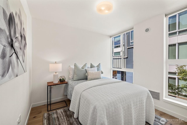 2414 NW 64th St Unit A, Seattle, WA 98107 - bedroom featuring wood finished floors, multiple windows, and baseboards
