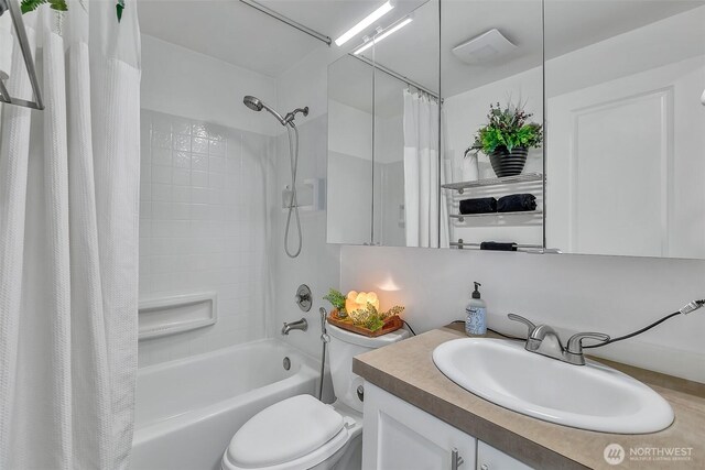 bathroom with vanity, toilet, and shower / tub combo with curtain