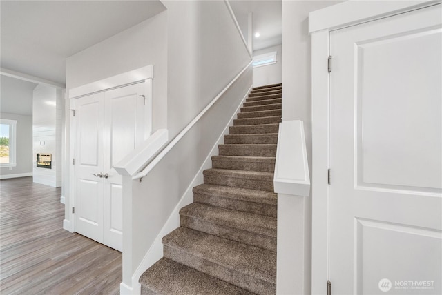 staircase featuring baseboards and wood finished floors