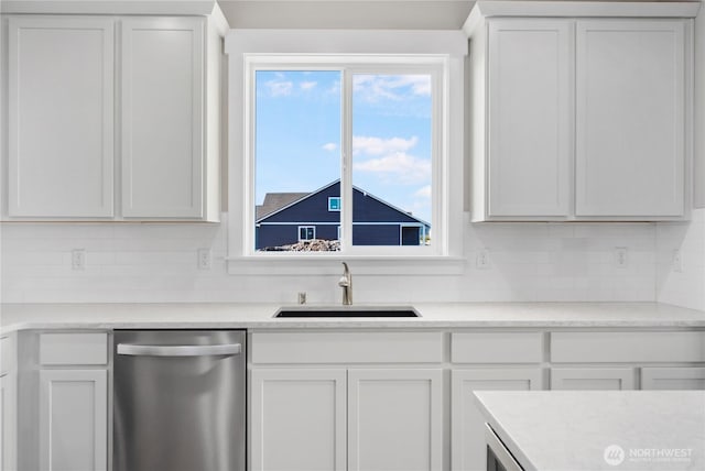 kitchen featuring tasteful backsplash, dishwasher, a sink, light countertops, and white cabinets