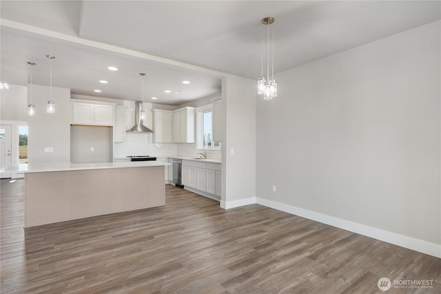 kitchen featuring stainless steel dishwasher, wood finished floors, light countertops, recessed lighting, and white cabinetry