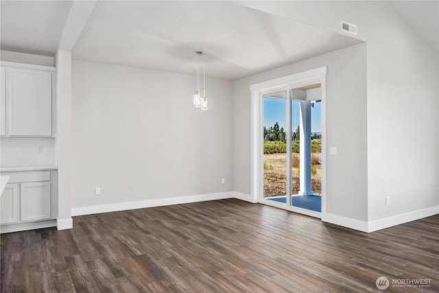 unfurnished dining area with visible vents, baseboards, dark wood-type flooring, and an inviting chandelier