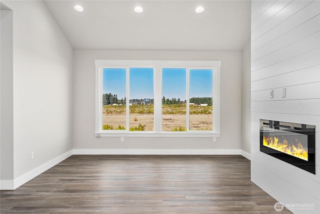unfurnished living room featuring baseboards, a fireplace, and recessed lighting
